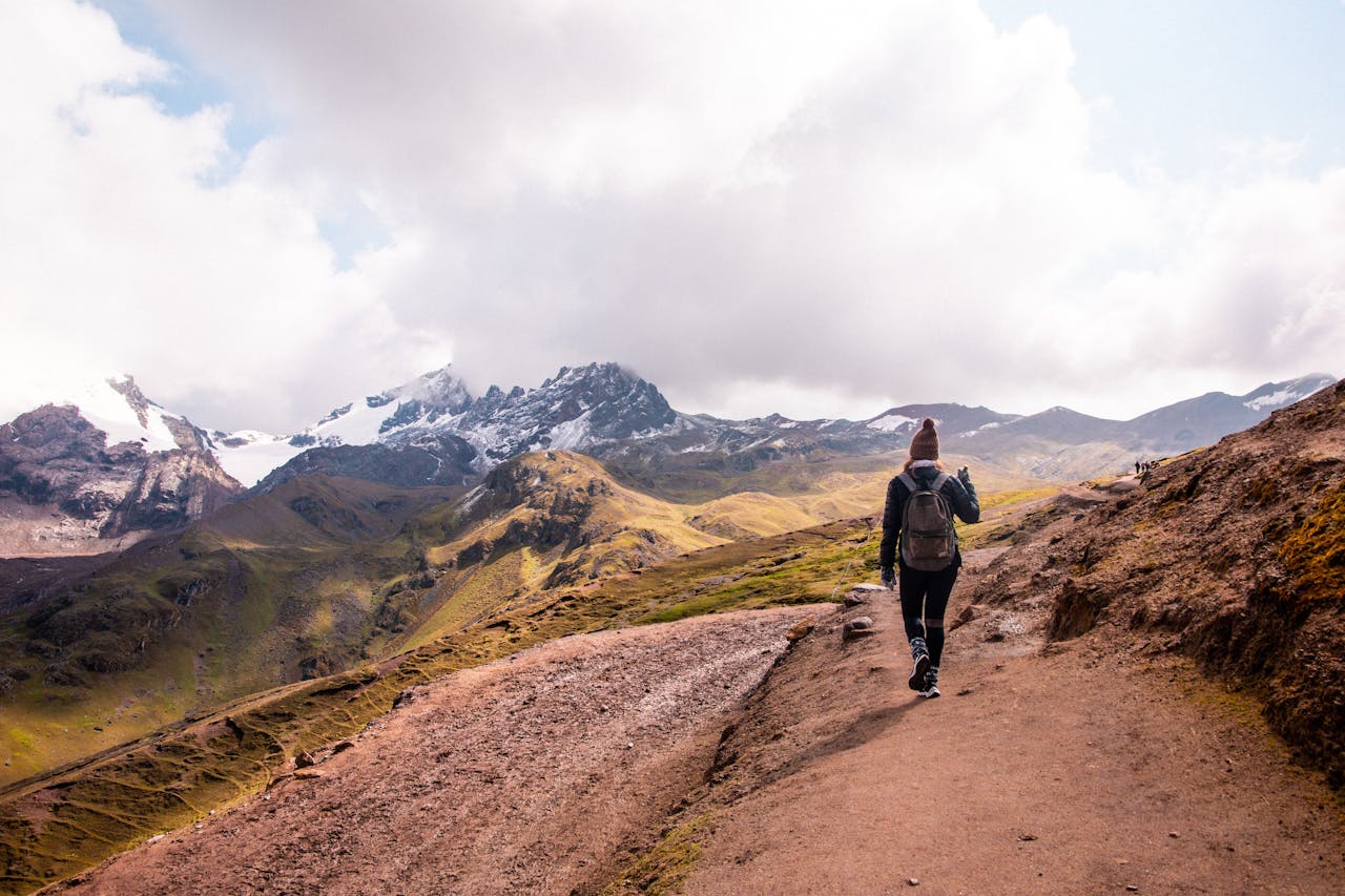 A woman hiking on a scenic trail in the Andes mountains of Cusco, Peru.